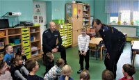 zdjęcie kolorowe na którym widać dwójkę policjantów i przedszkolaki