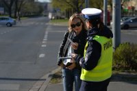 zdjęcie kolorowe na którym widać policjantkę która informuje o prowadzonej akcji patrz i słuchaj przy przejściu dla pieszych