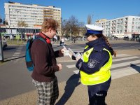 zdjęcie kolorowe na którym widać policjantkę która informuje o prowadzonej akcji patrz i słuchaj przy przejściu dla pieszych