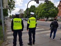 Zdjęcie kolorowe na którym widać dwóch policjantów obserwujących przejście dla pieszych w związku z działaniami pn. Niechronieni uczestnicy ruchu drogowego.