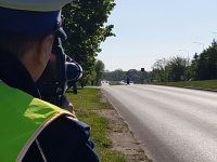 Zdjęcie kolorowe na którym widać policjanta obserwującego drogę w związku z działaniami pn. Niechronieni uczestnicy ruchu drogowego.