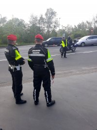zdjęcie na którym widać policjanta  umundurowanego zatrzymującego motocyklistę do kontroli oraz dwóch funkcjonariuszy ŻW