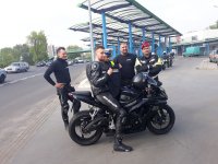 zdjęcie na którym widać policjanta  umundurowanego, motocyklistę który otrzymał koszulkę oraz dwóch motocyklistów i funkcjonariusza ŻW