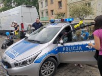 policjant na festynie rodzinnym, radiowóz który zwiedzają dzieci