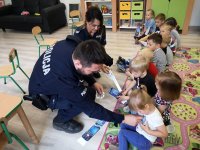 policjant i policjantka z dziećmi podczas nauki przez zabawę