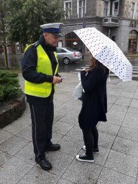 policjant z ruchu drogowego rozmawia z pieszą