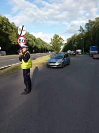 policjant mierzy prędkość na drodze