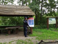 Policjant rozwieszający tablice informacyjne na terenie jeziora Głębokiego