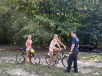 policjant i dwie kobiety na rowerach