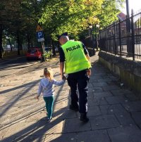 policjant prowadzi dziecko