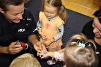 Policjant rozdający pieczątki policjanta dzieciom