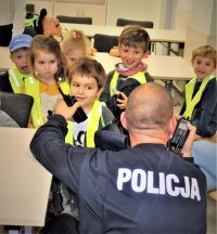 Policjant prezentujący dzieciom radiostację