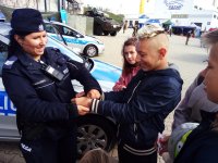 Policjantka z dziećmi uczestniczącymi w festynie