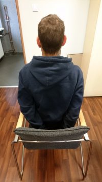 mężczyzna siedzący tyłem na krześle