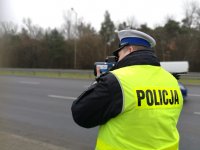 policjant mierzy prędkośći na drodze