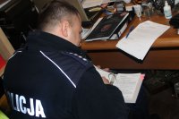 policjant wypełnia dokumentcję