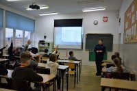 policjantka prowadzi prelekcje w szkole z uczniami