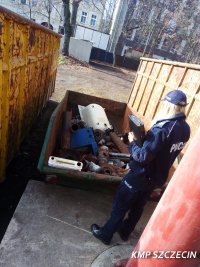 umundurowana policjantka kontroluje kontener ze złomem