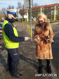 policjant wręcza odblask kobiecie