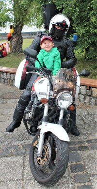zdjęcie na którym jest policjant na motorze z dzieckiem