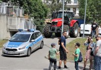 uczestnicy festynu w tle widoczny radiowóz i traktor