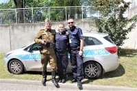 policjanci z mężczyzna na tle radiowozu