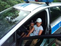 Dzieci siedzące w policyjnym radiowozie