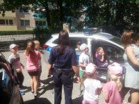 policjantka z dziećmi w tle radiowóz