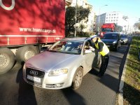 POLICJANTKA ROZDAJE ULOTKI I ODBLASKI PODCZAS KONTROLI SAMOCHODU