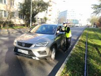 POLICJANTKA ROZDAJE ULOTKI I ODBLASKI PODCZAS KONTROLI SAMOCHODU