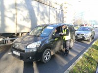 POLICJANTKA ROZDAJE ULOTKI I ODBLASKI PODCZAS KONTROLI SAMOCHODU