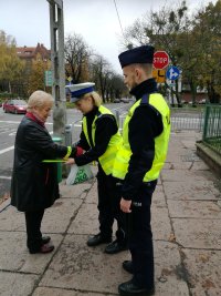 policjanci wręczający odblaski