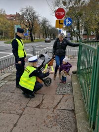 policjanci wręczający odblaski